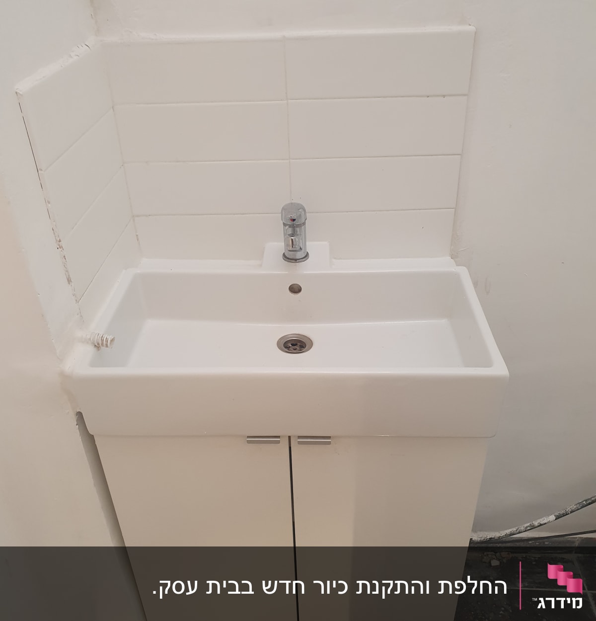 כיור לבן עם ברז כרום מותקן על ארון